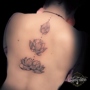 Tatouage fleur de lotus réalisé par le meilleur salon de tatouage en Gironde. Tatouage fleur de lotus style fin et féminin. Triple fleur de lotus qui éclos dans le dos, réalisé à Gradignan proche de Pessac et Talence.