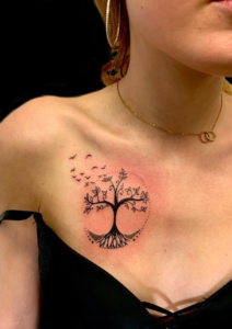 Tatouage arbre de vie minimaliste avec envolée d'oiseaux, sous la clavicule. Fin et féminin réalisé par les meilleurs tatoueur de Bordeaux proche de Lormont et Latresne