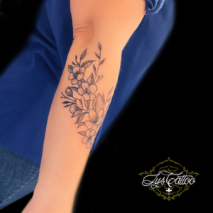 tatouage branche de cerisier japonais, sakura en noir et gris sur avant bras femme. réalisation par votre salon de tatouage de Villenave d'Orlon, proche de Pessac et Talence en Gironde
