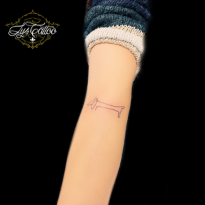 Tatouage avant bras femme, réalisation d’un petit chien en one Line, une seule ligne. Tatouage réalisé par de bons tatoueurs en Gironde à Villenave d’Ornon, proche de Blanquefort et Saint André de Cubzac