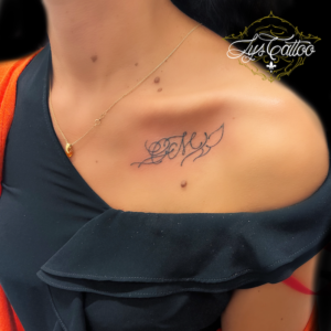 Tatouage initiale arabesques et petit papillon suggéré. Réalisation sur clavicule, côté cœur, par,la,meilleure tatoueuse de Gironde à Gradignan proche de Libourne et Eysines.