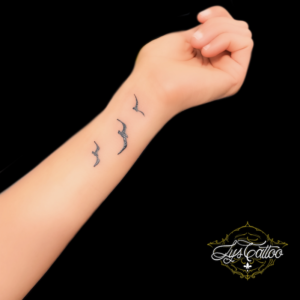Un tatouage représentant une envolée d'oiseaux peut symboliser la liberté, l'espoir et la légèreté. Cette image évoque souvent la beauté de la nature et la capacité des oiseaux à voyager librement dans le ciel. Les oiseaux en vol sont également associés à la transformation et au voyage spirituel, faisant de ce tatouage un choix populaire pour ceux qui cherchent à exprimer leur désir de liberté et de croissance personnelle. Au salon Lys Tattoo à Gragignan, près de Bordeaux, nos artistes experts peuvent créer un tatouage personnalisé représentant une envolée d'oiseaux qui capture toute la grâce et la fluidité de ce mouvement. Que vous souhaitiez un design réaliste mettant en valeur les détails des plumes ou une interprétation plus stylisée et artistique, nous sommes là pour vous aider à créer un tatouage qui reflète votre connexion avec la nature et votre désir de liberté avec professionnalisme et créativité