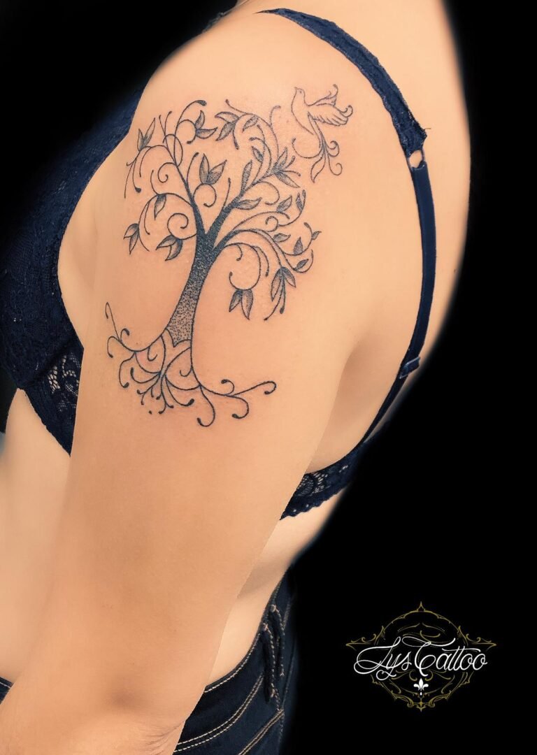 Tatouage arbre de vie avec oiseau en vol sur l'épaule