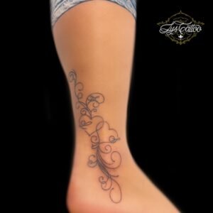 Tatouage délicat sur la cheville représentant des arabesques et volutes élégantes en fine ligne noire. Réalisé par Lys Tattoo, basé à Gradignan et bientôt à Villenave d’Ornon.