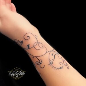 Tatouage fin et élégant de motifs floraux sur le poignet, réalisé par Lys Tattoo à Villenave d’Ornon, près de Bordeaux, Pessac et Talence.