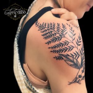 Tatouage botanique représentant des fougères et des feuilles délicates sur l’épaule et le haut du bras, réalisé par Lys Tattoo au salon Lys Tattoo à Gradignan, près de Bordeaux.