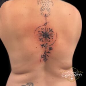 Tatouage boussole géométrique sur la colonne vertébrale, avec avion et motifs floraux, réalisé par Lys Tattoo à Gradignan, près de Bordeaux et Pessac.