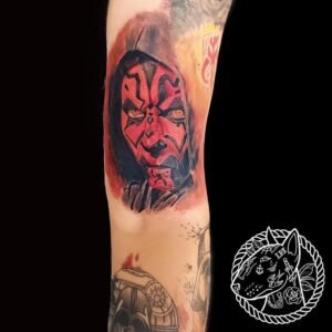 Tatouage réaliste de Dark Maul, personnage de Star Wars, en noir et rouge avec des effets de peinture et de texture, réalisé par Le Bull Tatoué chez Lys Tattoo.