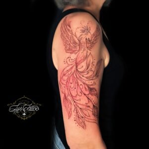 Tatouage de phénix stylisé en noir et rouge sur le bras, réalisé par Lys Tattoo chez Lys Tattoo à Gradignan (Bordeaux)