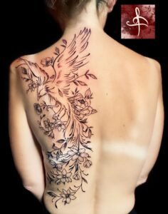 Tatouage représentant un phénix en plein vol entouré de fleurs délicates, réalisé en lignes fines et détaillées sur le dos, par Rhum1 Tattoo au Lys Tattoo.