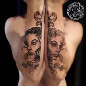 Tatouage symétrique représentant deux visages féminins entourés de motifs décoratifs, réalisé sur les bras par Le Bull Tatoué au salon Lys Tattoo.