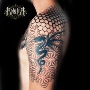 Épaule/haut de bras géométrique avec dragon blackwork, alvéoles et asanoha – Kaly Ink Bordeaux