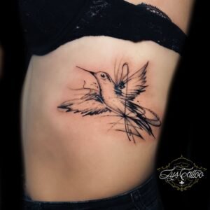 Tatouage colibri sur flanc/côtes en fine line, traits esquissés et touches de dotwork – Lys Tattoo Bordeaux