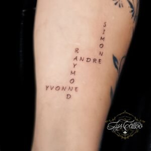 Tatouage prénoms en forme de mots croisés, lettrage minimal sur bras – Lys Tattoo Bordeaux