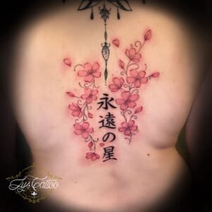 Tatouage dos fleurs de cerisier roses et idéogrammes japonais en colonne – Lys Tattoo Bordeaux