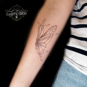 Tatouage papillon minimaliste en fine line et dotwork sur avant-bras – Lys Tattoo Bordeaux