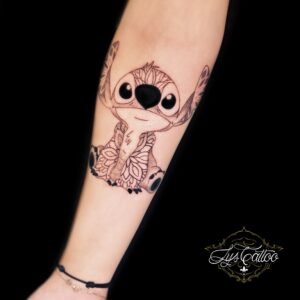 Tatouage personnage Stitch mignon style cartoon en fine line/dotwork sur avant-bras – Lys Tattoo Bordeaux