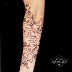 Tatouage avant-bras bouquet floral en fine line et dotwork, grandes fleurs et feuillage – Lys Tattoo Bordeaux