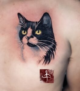 Tatouage portrait de chat noir et blanc en couleur réaliste, yeux jaunes – Rhum1 Tattoo Bordeaux