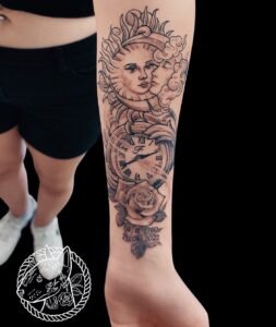 Tatouage avant-bras soleil et lune, montre gousset et rose en noir et gris, dates commémoratives