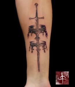 Tatouage épée ornementale traversant deux couronnes, noir et gris – mollet/avant-bras (Rhum1 Tattoo)