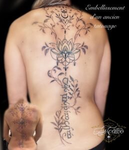 Embellissement d’un ancien tatouage sur le dos avec lotus central et colonne ornementale, noir et gris, Lys Tattoo.