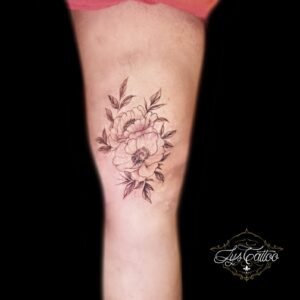 Tatouage bouquet de pivoines en ligne fine sur la cuisse, au-dessus du genou