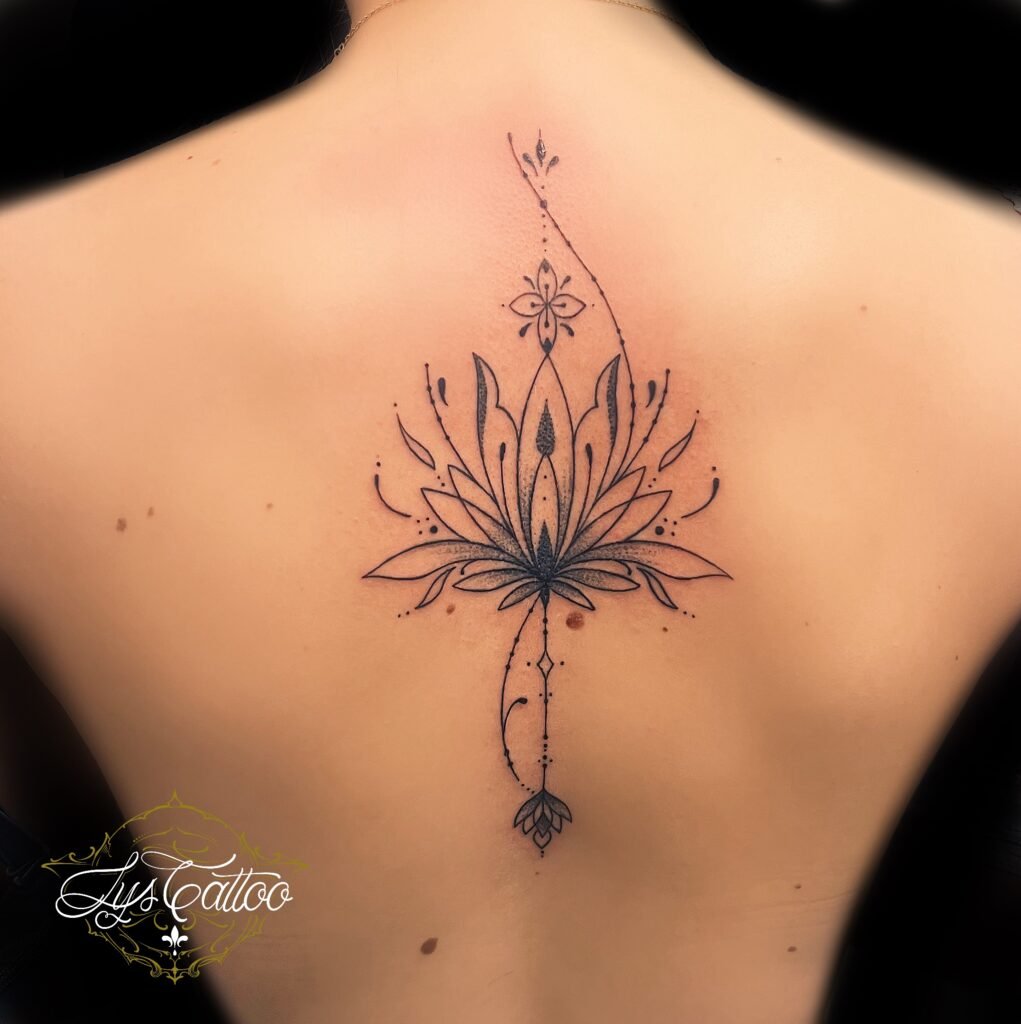 Tatouage de fleur de lotus ornementale en fineline sur le haut du dos, réalisé chez Lys Tattoo à Villenave-d’Ornon.