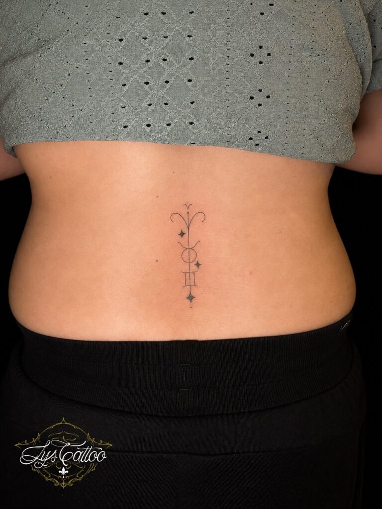 Tatouage minimaliste et fin en ligne sur le bas du dos réalisé chez Lys Tattoo à Villenave-d’Ornon près de Bordeaux.